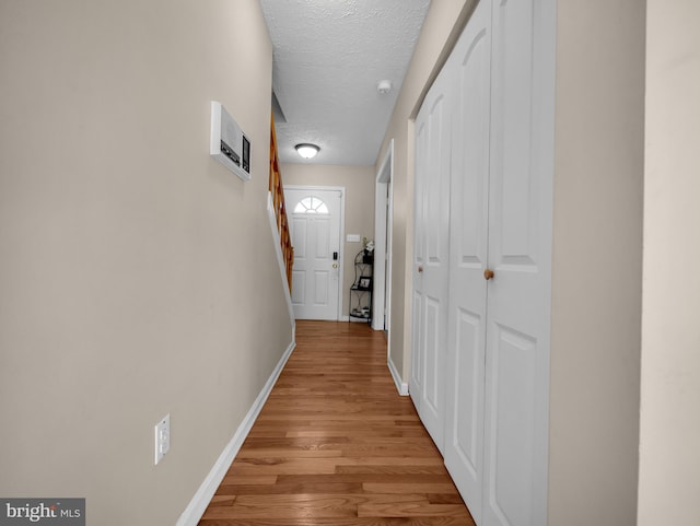 hallway featuring a textured ceiling and light hardwood / wood-style flooring