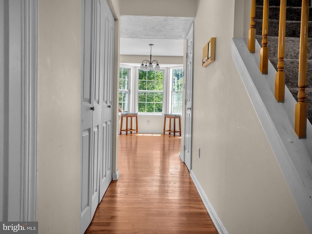 corridor featuring light hardwood / wood-style floors and a chandelier