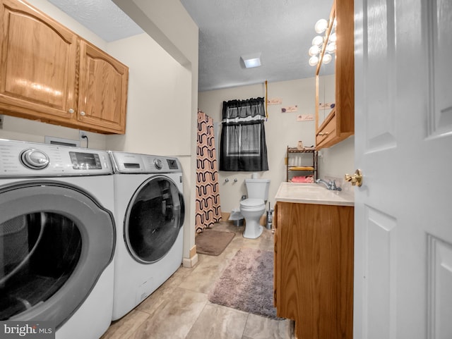 washroom featuring sink, washing machine and dryer, and a textured ceiling