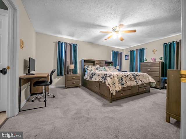 carpeted bedroom featuring ceiling fan and a textured ceiling