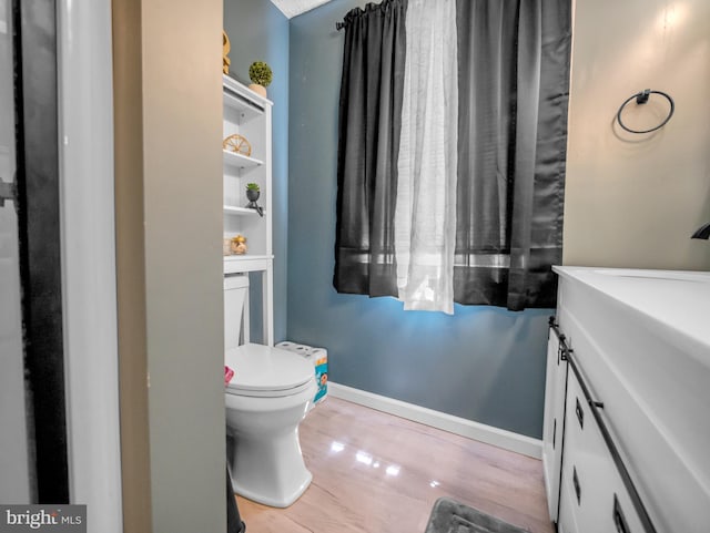 bathroom with vanity, toilet, and wood-type flooring