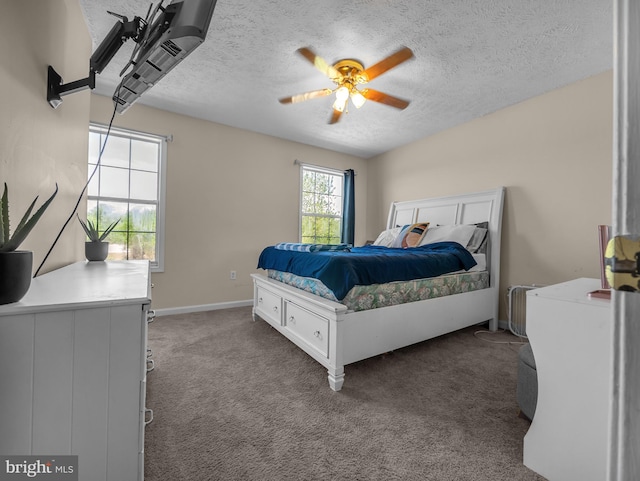 carpeted bedroom featuring ceiling fan and a textured ceiling