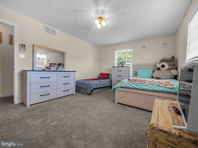 carpeted bedroom featuring a textured ceiling