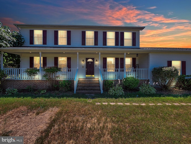 view of front of house with covered porch and a lawn