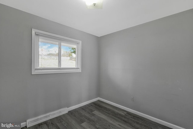 spare room featuring dark wood-type flooring