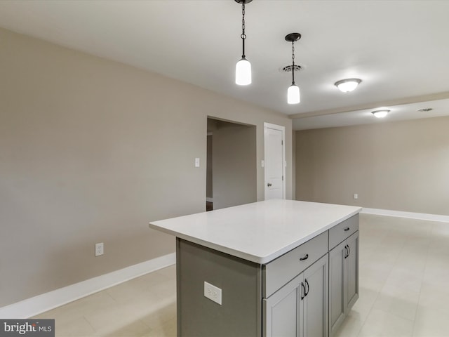 kitchen with gray cabinets, a center island, and hanging light fixtures