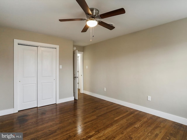 unfurnished bedroom with dark wood-type flooring, ceiling fan, and a closet