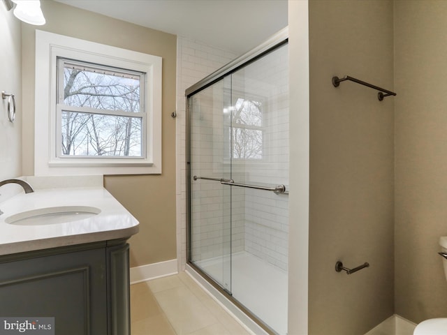 bathroom with tile patterned flooring, toilet, vanity, and walk in shower