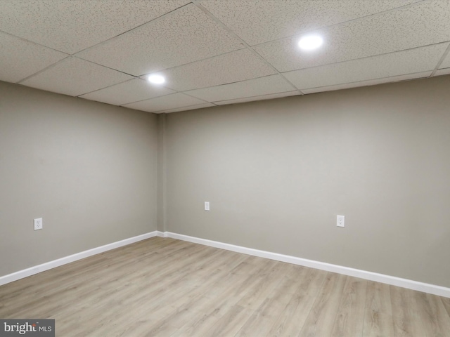 spare room featuring a drop ceiling and hardwood / wood-style floors