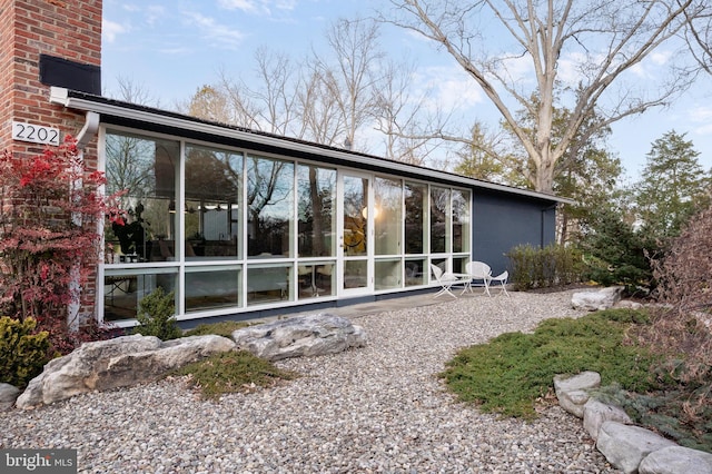 back of property with a sunroom