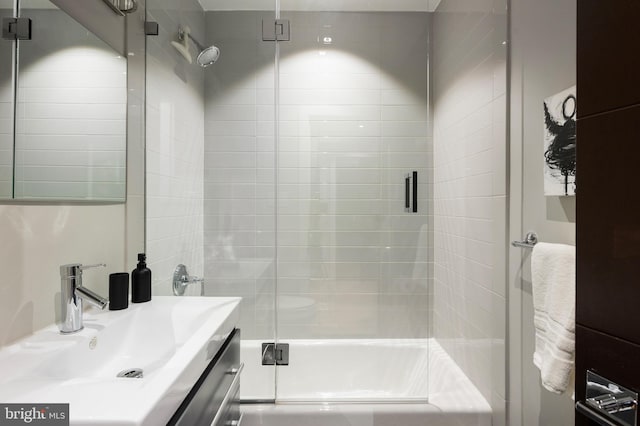 bathroom with vanity and bath / shower combo with glass door