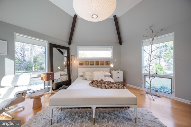 bedroom with vaulted ceiling with beams and hardwood / wood-style floors