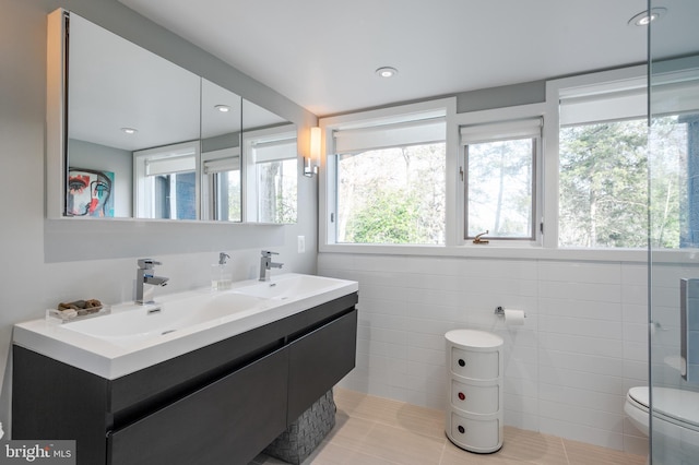 bathroom featuring tile walls, vanity, tile patterned floors, and toilet