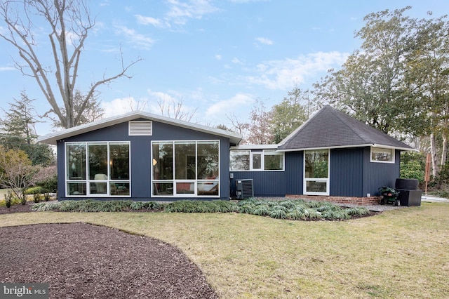 back of property featuring a yard and central air condition unit