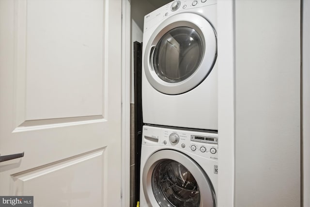 clothes washing area featuring stacked washer and dryer