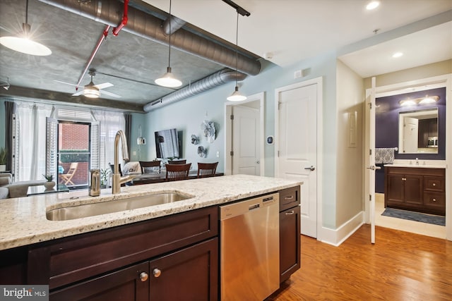 kitchen with hanging light fixtures, dishwasher, sink, and light hardwood / wood-style floors