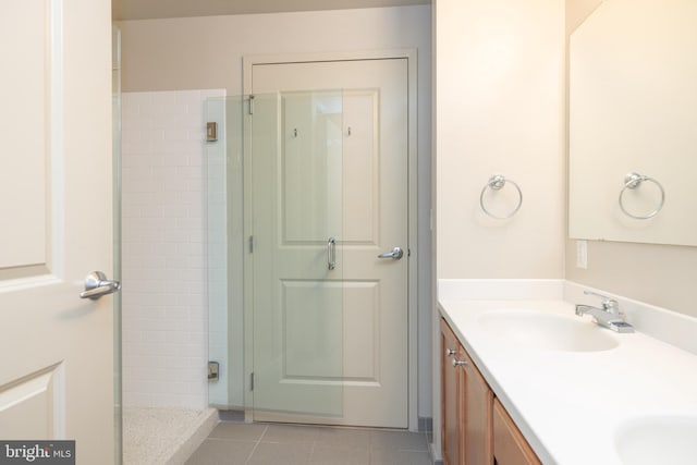 bathroom with tile patterned floors, vanity, and a tile shower