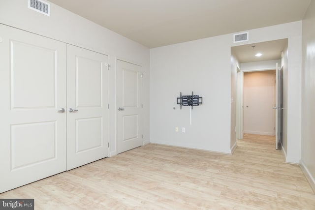 unfurnished bedroom featuring light hardwood / wood-style flooring and a closet