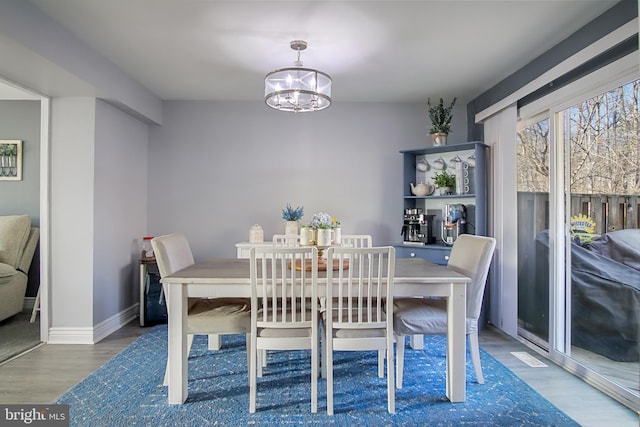 dining area featuring dark wood-type flooring and a notable chandelier