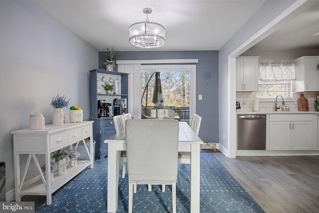 dining room with an inviting chandelier, plenty of natural light, dark wood-type flooring, and sink