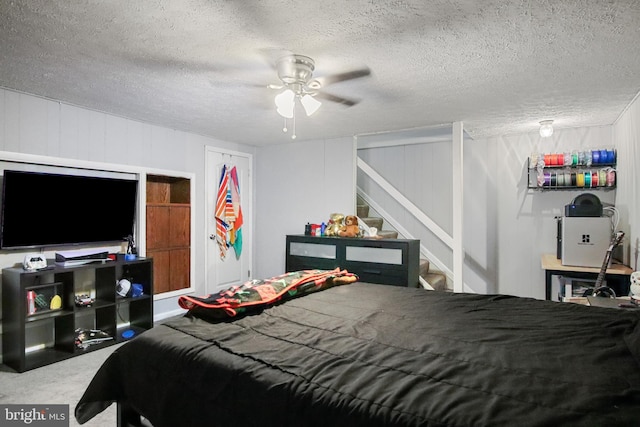 bedroom with ceiling fan and a textured ceiling