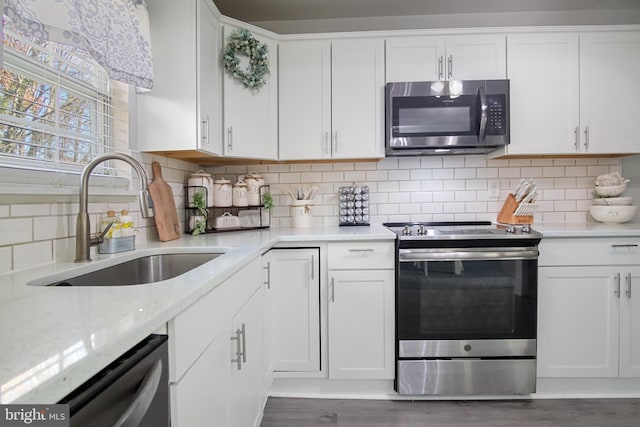 kitchen with stainless steel appliances, sink, and white cabinets