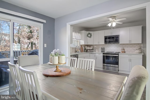 dining space featuring sink and ceiling fan