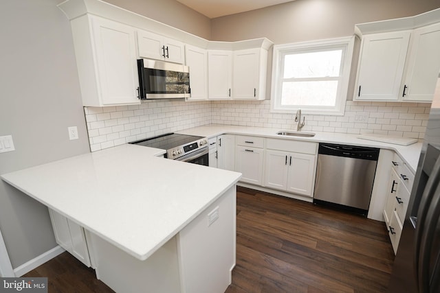 kitchen with white cabinetry, appliances with stainless steel finishes, sink, and kitchen peninsula