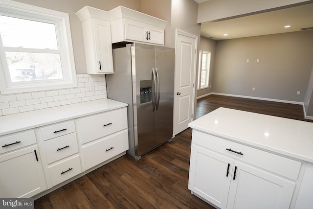 kitchen with dark hardwood / wood-style flooring, decorative backsplash, white cabinets, and stainless steel refrigerator with ice dispenser