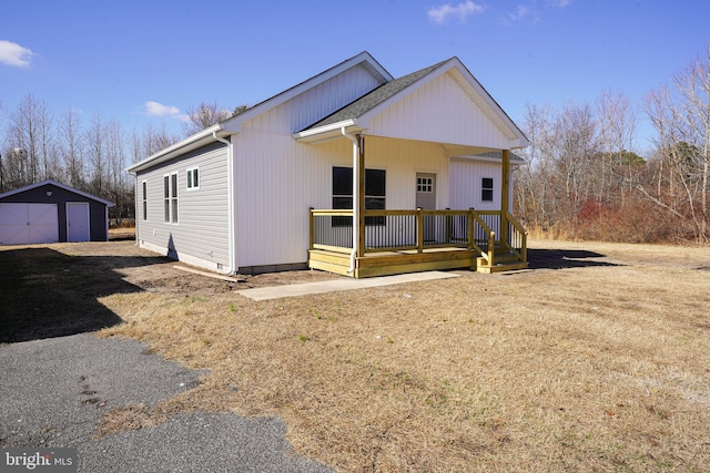 view of front of home with a front lawn, covered porch, and a storage unit