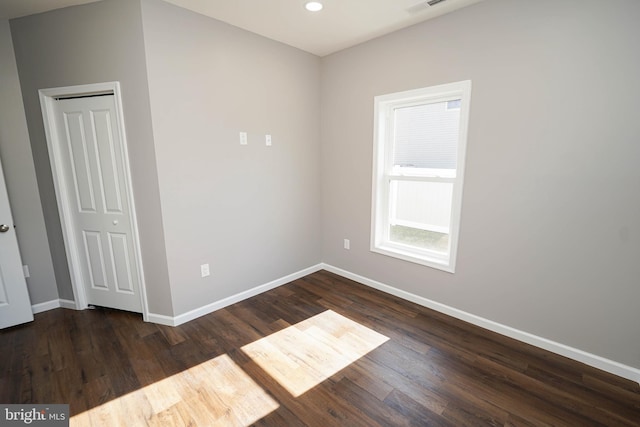 unfurnished room with dark hardwood / wood-style flooring