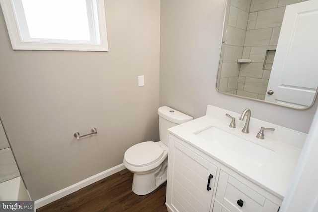 bathroom with wood-type flooring, vanity, and toilet