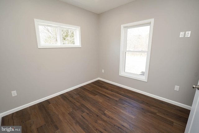 spare room featuring plenty of natural light and dark hardwood / wood-style floors