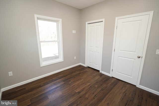 unfurnished bedroom featuring a closet and dark hardwood / wood-style floors