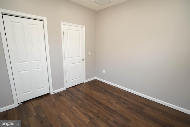 unfurnished bedroom featuring dark hardwood / wood-style flooring