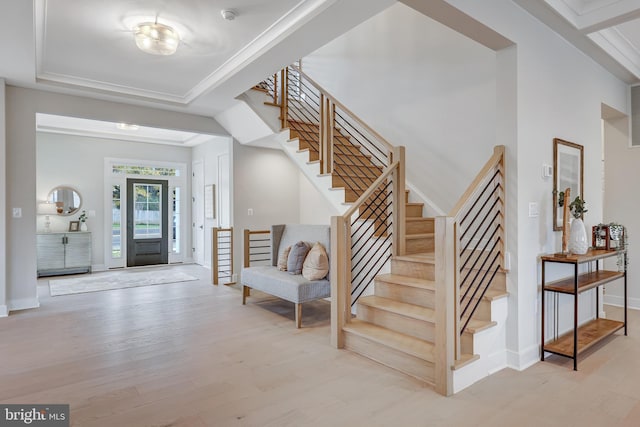 foyer entrance featuring a raised ceiling and light wood-type flooring