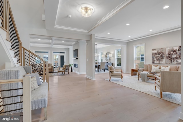 interior space with beamed ceiling, ornamental molding, coffered ceiling, and light wood-type flooring