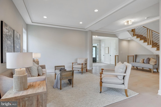 living room featuring ornamental molding, a healthy amount of sunlight, and light wood-type flooring