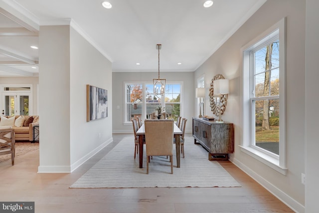 dining space with ornamental molding, a chandelier, and light hardwood / wood-style floors