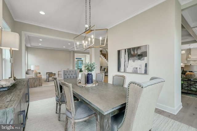 dining area with light hardwood / wood-style flooring, ornamental molding, and a chandelier