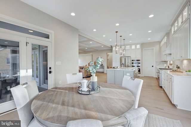 dining room featuring coffered ceiling, sink, beam ceiling, and light wood-type flooring