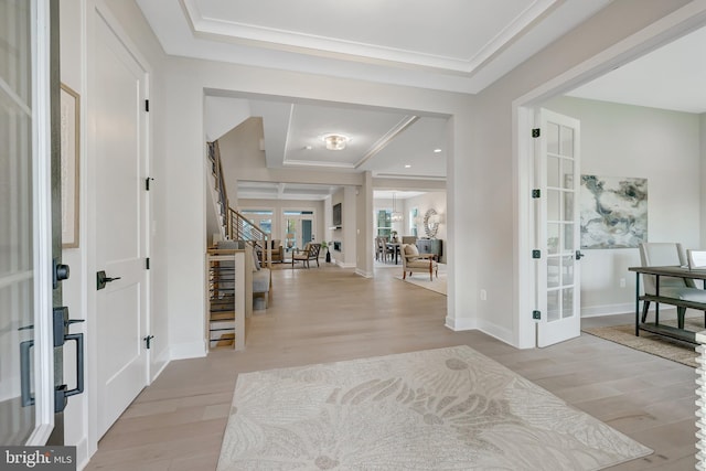 entrance foyer with french doors, ornamental molding, and light wood-type flooring