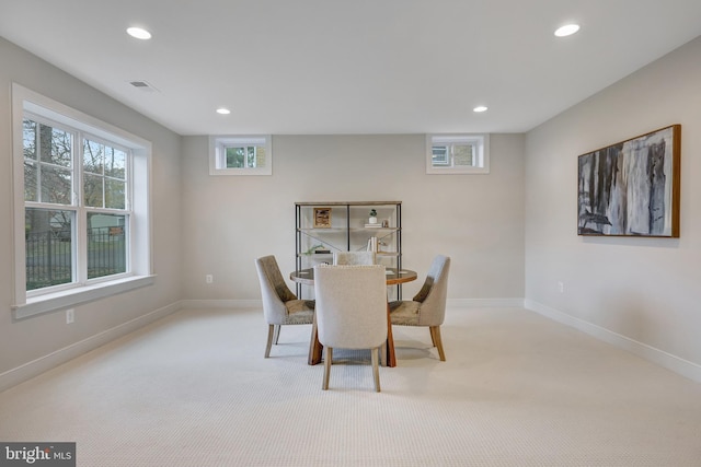 dining room featuring light carpet and plenty of natural light