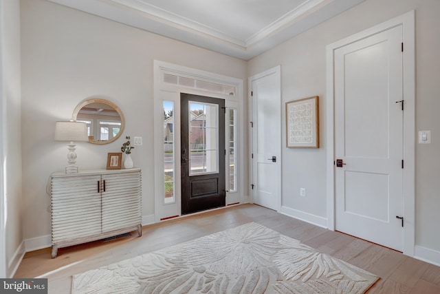 foyer with crown molding and light hardwood / wood-style flooring