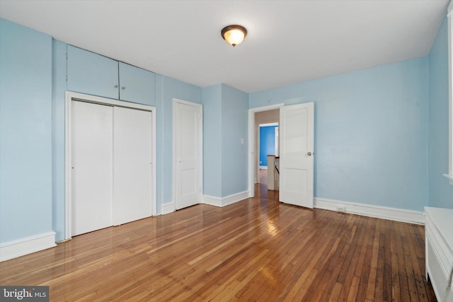 unfurnished bedroom with wood-type flooring and a closet