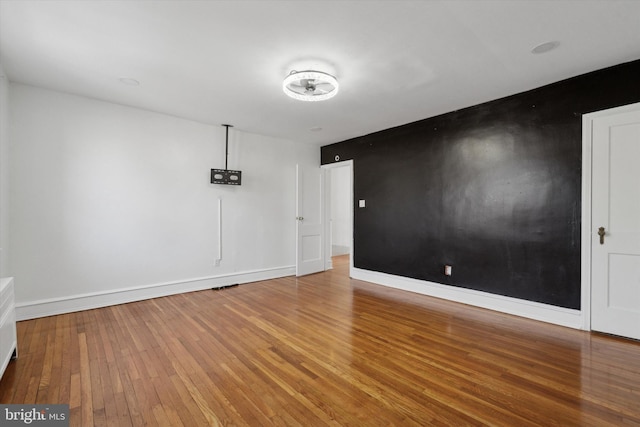 unfurnished room with hardwood / wood-style floors