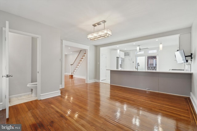 unfurnished living room with sink and light hardwood / wood-style floors