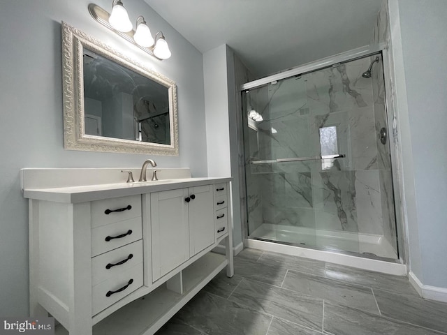 bathroom featuring baseboards, vanity, and a marble finish shower