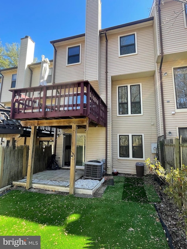 back of property with a lawn, a fenced backyard, a chimney, central air condition unit, and a patio area