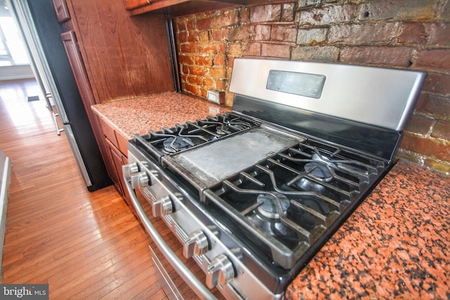 room details featuring gas range, refrigerator, and hardwood / wood-style flooring